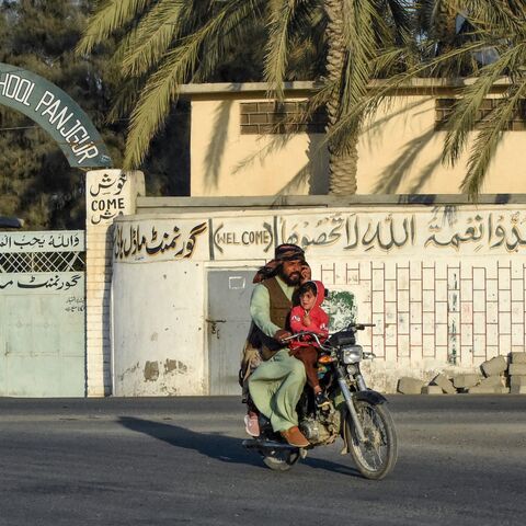 A motorcyclist rides past a high school at Panjgur district in Balochistan province on Jan. 17, 2024. 