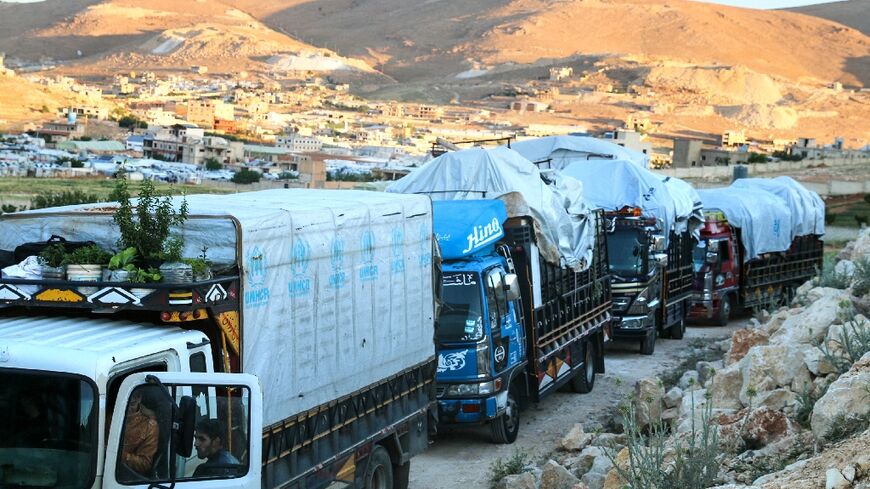 Syrian refugees head home from Lebanon in a convoy of trucks piled high with their belongings