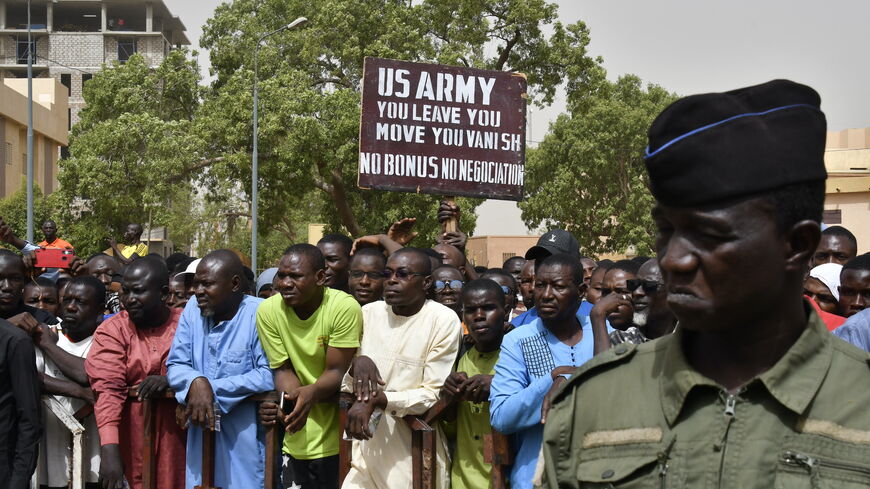 Protesters gather as a man holds up a sign demanding that soldiers from the United States Army leave Niger without negotiation during a demonstration in Niamey, on April 13, 2024. 