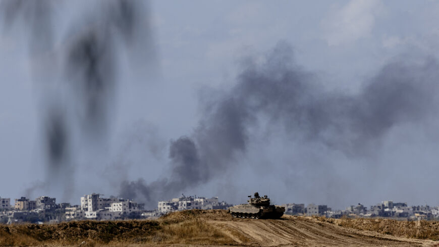 Smoke rises over Gaza as an Israeli tank takes position along the border with the Gaza Strip, southern Israel, May 13, 2024.