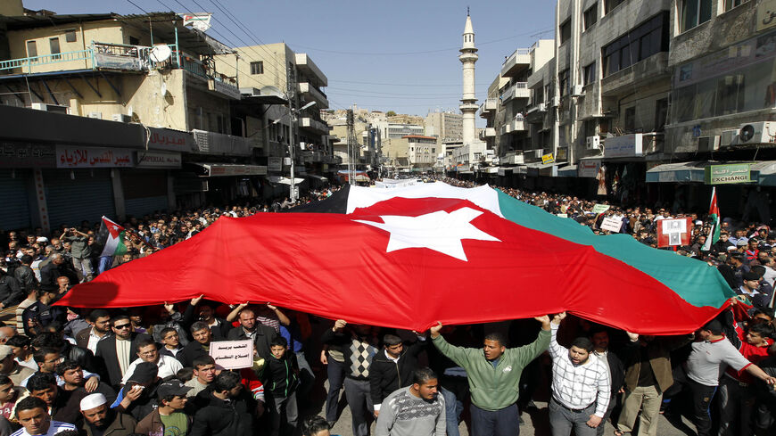 Thousands of Jordanians hold a giant national flag during a demonstration to demand regime reforms, a day after Prime Minister Maaruf Bakhit rejected calls for a constitutional monarchy, March 4, 2011 in Amman, Jordan, March 4, 2011.