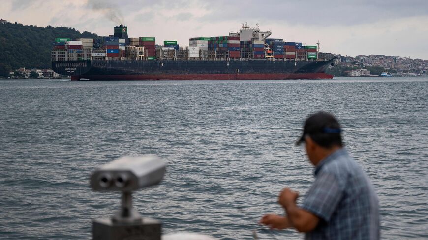 A man fishes as Hong-Kong-flagged container ship "Joseph Schulte" transits Bosphorus in Istanbul, on August 18, 2023. The Hong Kong-flagged Joseph Schulte left the port of Odesa on August 17 -- the first vessel to directly challenge Russia's new bid to seal Ukraine's access to the Black Sea. Marine traffic sites showed it approaching its final destination in Istanbul after moving along a western route that avoided international waters in favour of those controlled by NATO members Romania and Bulgaria. (Phot