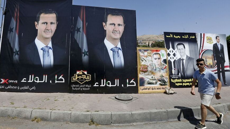 A man walks past a poster of President Bashar al-Assad, a candidate in the presidential election, Damascus, Syria, May 17, 2021.