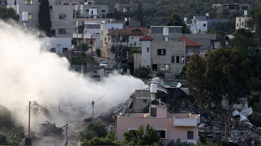 Smoke pours out of a besieged bilding during an Israeli raid on the village of Deir al-Ghusun in the occupied West Bank