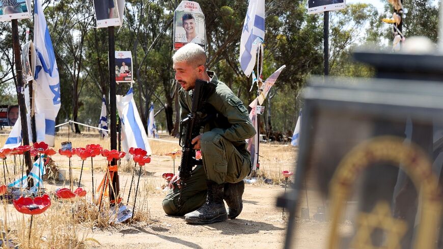An Israeli soldier mourns at a memorial for people taken hostage or killed in Hamas's attack on the Supernova music festival on October 7, 2023, at the site of the festival near Reim, southern Israel