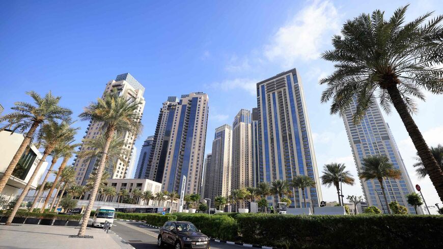 Cars drive along a street in front of high-rise buildings in Dubai, on February 18, 2023. - Home to towering skyscrapers and ultra-luxury villas, Dubai saw record real estate transactions in 2022, largely due to an influx of wealthy investors, especially from Russia. (Photo by Karim SAHIB / AFP) (Photo by KARIM SAHIB/AFP via Getty Images)