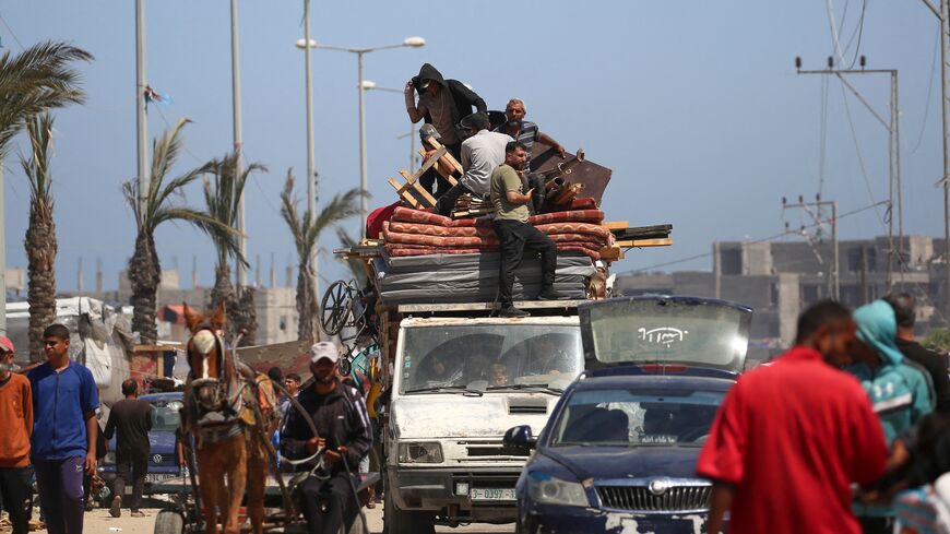 Displaced Palestinians transport their belongings on the back of a truck as they flee al-Mawasi to a safer area in Rafah, in the southern Gaza Strip, May 9, 2024.