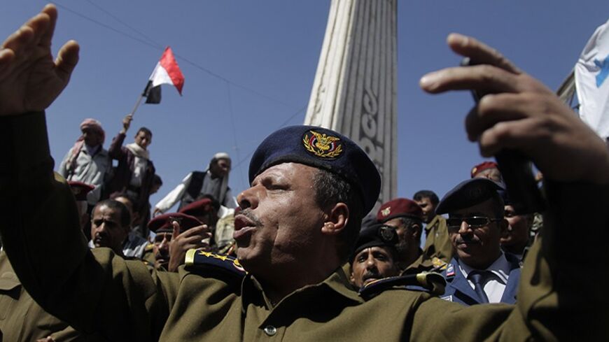 A police officer gestures as he joins other police and army officers during an anti-government demonstration at a Change Square protest camp in Sanaa March 3, 2014. REUTERS/Khaled Abdullah (YEMEN - Tags: POLITICS MILITARY CIVIL UNREST) - RTR3FZGW