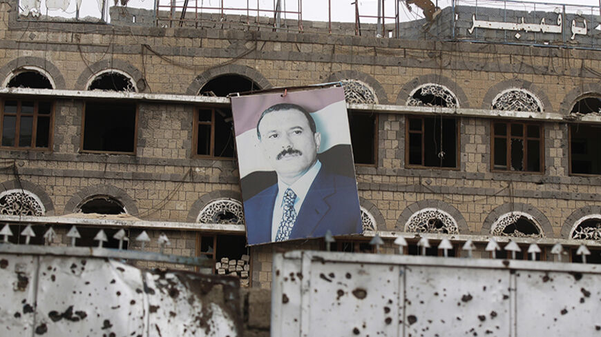 A portrait of Yemen's former president Ali Abdullah Saleh hangs on the wall of the former headquarters of his General People's Congress party in Sanaa May 12, 2014. The building was damaged during the 2011 clashes between forces loyal to Saleh and tribal militias opposing him during the uprising against his rule. REUTERS/Khaled Abdullah (YEMEN - Tags: POLITICS CIVIL UNREST TPX IMAGES OF THE DAY) - RTR3OTK8