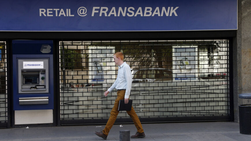 A man walks past a closed branch of Fransabank in Beirut September 4, 2013. Banks and private business corporations saw a one-day strike being held in many parts of Lebanon on Wednesday, organised by economic committees aiming to pressure Lebanese political parties to form a cabinet to maintain the country's economy, local media reported. REUTERS/Mohamed Azakir (LEBANON - Tags: BUSINESS) - RTX136NZ