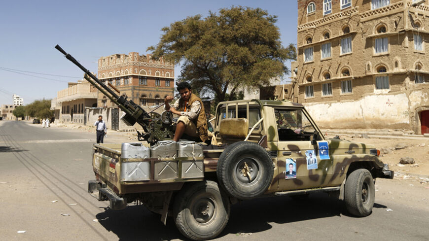 A follower of the Shi'ite Houthi movement mans a machine gun mounted on a military pick up in Sanaa October 20, 2014. The truck was taken by the movement's fighters during recent clashes with army soldiers in Sanaa. REUTERS/Khaled Abdullah (YEMEN - Tags: POLITICS CIVIL UNREST MILITARY) - RTR4AU1L