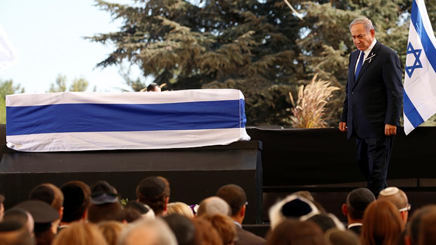 Israeli Prime Minister Benjamin Netanyahu walks past the casket of former Israeli president Shimon Peres after speaking at his funeral at the Mount Herzl cemetery in Jerusalem, September 30, 2016.   REUTERS/Kevin Lamarque  - RTSQ6C5