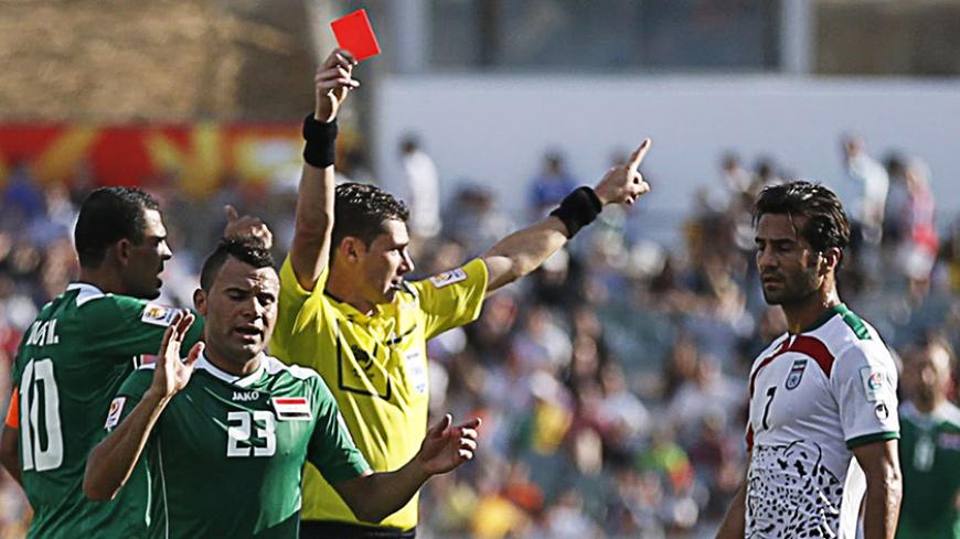 Referee Benjamin Williams of Australia shows the red card following a second yellow card to Iran's Mehrdad Pooladi (not pictured) next to Iraq players as Iran's Masoud Shojaei (R) reacts during their Asian Cup quarter-final soccer match at the Canberra stadium in Canberra January 23, 2015.  REUTERS/Tim Wimborne (AUSTRALIA  - Tags: SOCCER SPORT)   - RTR4MKIY