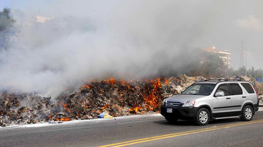 A car drives past burning garbage set on fire by residents, in Baabda near Beirut, Lebanon August 24, 2015. Lebanese protest organisers called for a fresh demonstration against the government on Saturday after two days of rallies that turned violent in central Beirut and wounded scores of people. The "You Stink" campaign has mobilised against the government's failure to solve a garbage disposal crisis, bringing thousands of people onto the streets in protests that have threatened the survival of the cabinet