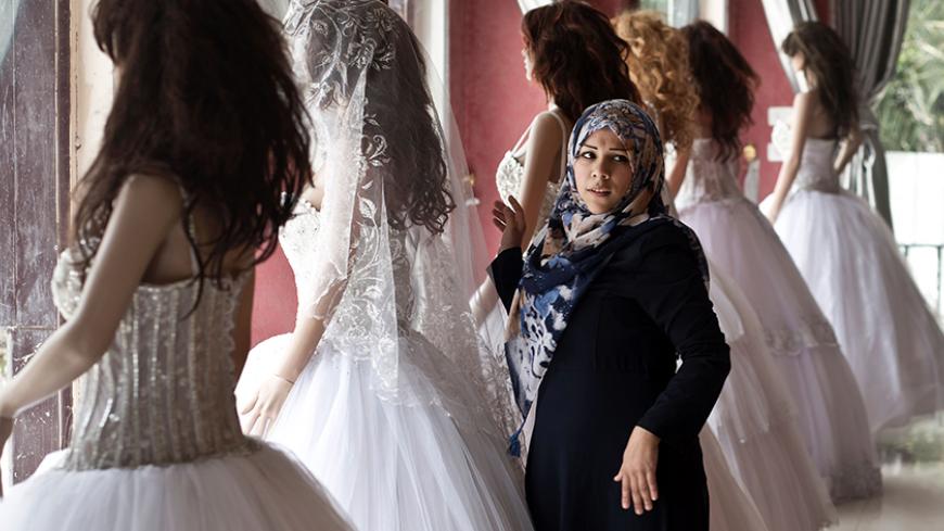 A Palestinian girl looks at wedding dresses at a shop in Gaza City on April 5, 2016.
In the coastal Palestinian enclave, where youth unemployment is over 60 percent and 80 percent of the 1.8 million residents depend on humanitarian aid, marriage is a luxury.

 / AFP / MAHMUD HAMS        (Photo credit should read MAHMUD HAMS/AFP/Getty Images)