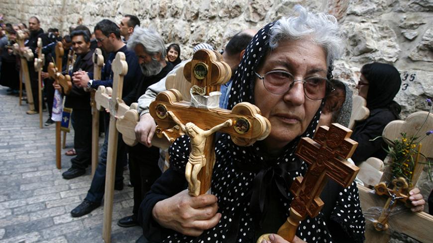 Orthodox Christians hold crosses as they wait along Via Dolorosa before a Good Friday procession in Jerusalem's Old City April 22, 2011. Christians retraced the route Jesus Christ took along the Via Dolorosa to his crucifixion in the Church of the Holy Sepulchre. REUTERS/Baz Ratner (JERUSALEM - Tags: RELIGION) - RTR2LI7U