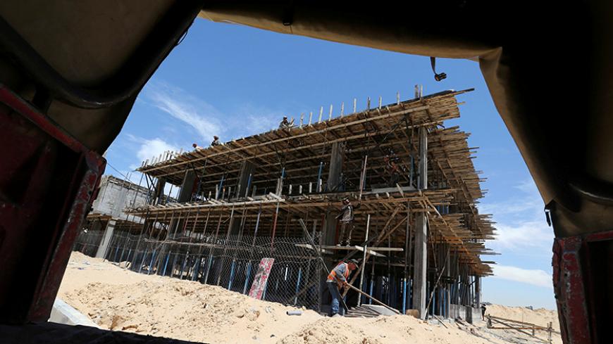 Palestinian workers work on a Qatari-funded construction project in the southern Gaza Strip June 7, 2017. REUTERS/Ibraheem Abu Mustafa - RTX39GD0
