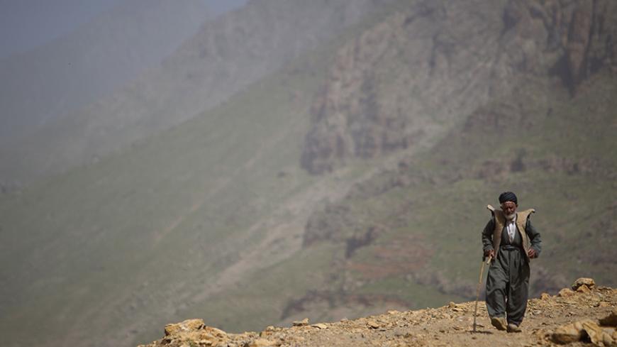 An Iranian Sunni Kurd walks along a mountain in Ouraman Takht village in Kurdistan province, about 620 km (385 miles) west of Tehran, May 12, 2011. Iranian Shi'ite and Sunni Kurds live in harmony with each other in Ouraman Takht, although Sunni is the religion of the majority of the people. REUTERS/Morteza Nikoubazl (IRAN - Tags: RELIGION SOCIETY IMAGES OF THE DAY) - RTR2MC61