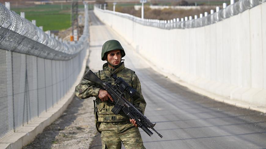 A Turkish soldier patrols along a wall on the border line between Turkey and Syria near the southeastern city of Kilis, Turkey, March 2, 2017. REUTERS/Murad Sezer - RTS114TG