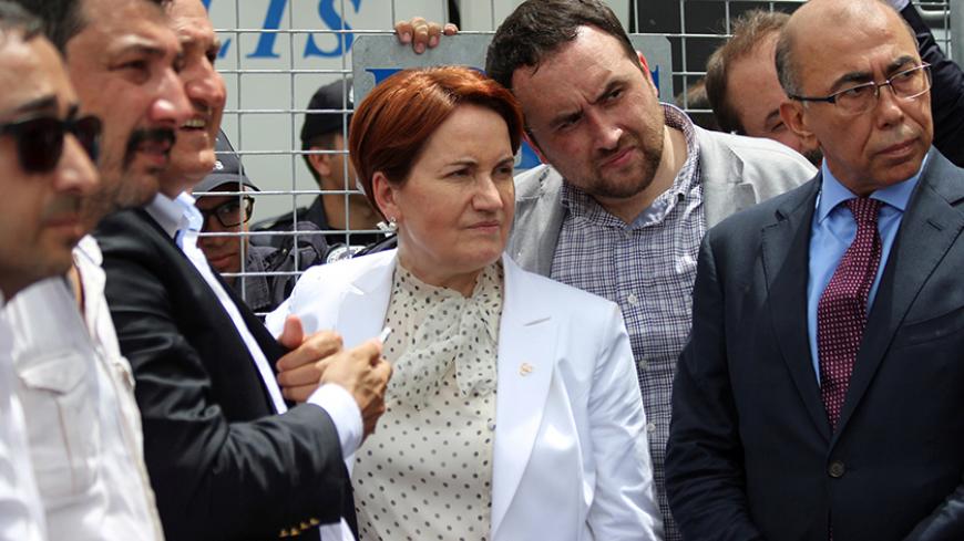 Meral Aksener (C), former interior minister and a lawmaker from Nationalist Movement Party (MHP), stands before the security barriers as police seal off a hotel, preventing dissidents from holding a party congress, in Ankara, Turkey, May 15, 2016. REUTERS/Tumay Berkin/File Photo  - RTX2FHJV