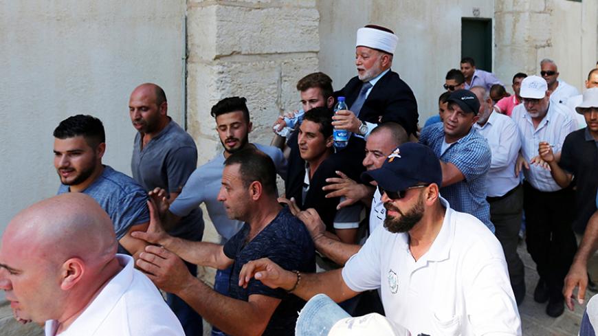 Sheikh Mohammad Hussein, the Grand Mufti of Jerusalem, is carried by Palestinians upon their entry into the compound known to Muslims as Noble Sanctuary and to Jews as Temple Mount after Israel removed all security measures it had installed at the compound, in Jerusalem's Old City July 27, 2017. REUTERS/Muammar Awad - RTX3D5A8