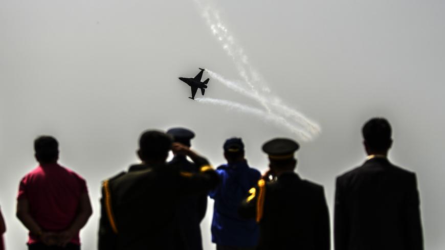A Turkish air force patroller flies by as people watch the ceremony celebrating the 99th anniversary of Anzac Day in Canakkale on April 24, 2014. A dawn ceremony on April 25 marks the time of the first landings of the Australian and New Zealand Army Corps (ANZAC) at the Gallipoli peninsula in the ill-fated Allied campaign to take the Dardanelles Strait from the Ottoman Empire. In the ensuing eight months of fighting, about 11,500 ANZAC troops were killed, fighting alongside British, Indian and French soldie