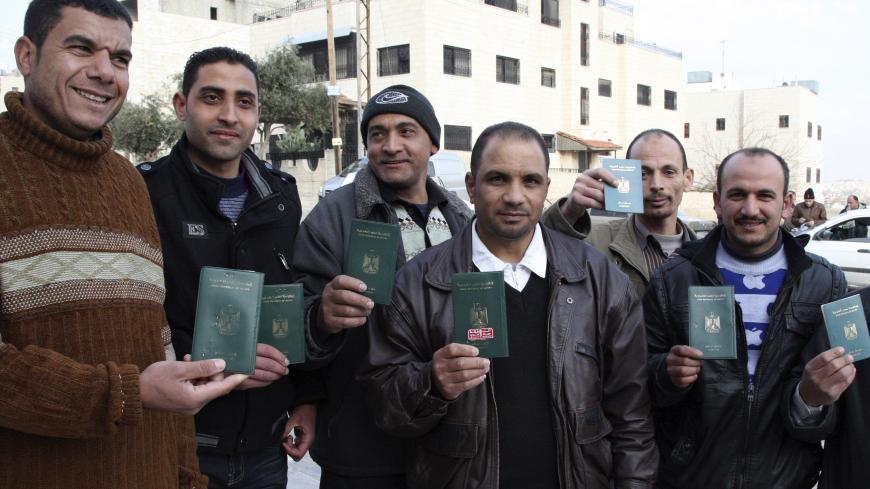 Egyptian men pose with their passports before voting in a referendum on the country's new constitution at the Egyptian embassy in Amman January 9, 2014. Egyptians living outside the country on Wednesday began voting in the referendum on the new constitution. The referendum marks the first time Egyptians have voted since the removal of President Mohamed Mursi in July, and is seen as much as a public vote of confidence on the roadmap and army chief Abdel Fattah al-Sisi as the constitution itself. REUTERS/Maje