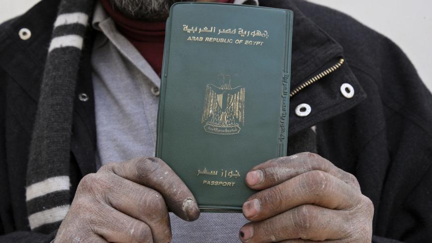An Egyptian man shows his passport after voting in a referendum on his country's new constitution at the Egyptian embassy in Amman January 9, 2014. Egyptians living outside the country on Wednesday began voting in a referendum on the new constitution. The referendum marks the first time Egyptians have voted since the removal of President Mohamed Mursi in July, and is seen as much as a public vote of confidence on the roadmap and army chief Abdel Fattah al-Sisi as the constitution itself. REUTERS/Majed Jaber