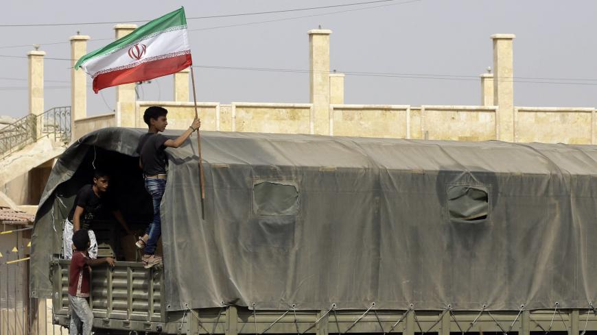 A Syrian boy holds the Iranian flag as a truck carrying aid provided by Iran arrives in the eastern city of Deir Ezzor on September 20, 2017 while Syrian government forces continue to press forward with Russian air cover in the offensive against Islamic State group jihadists across the province.
Two separate offensives are under way against the jihadists in the area -- one by the US-backed Syrian Democratic Forces, the other by Russian-backed government forces. The Syrian army now controls around 70 percent