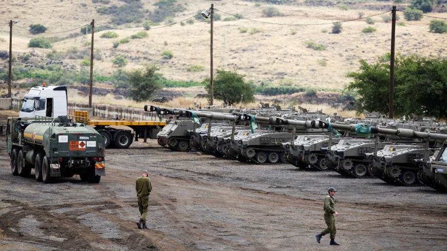 Israeli soldiers walk near mobile artillery units in the Israeli-occupied Golan Heights, Israel May 9, 2018. REUTERS/Amir Cohen - RC1F39D55B70