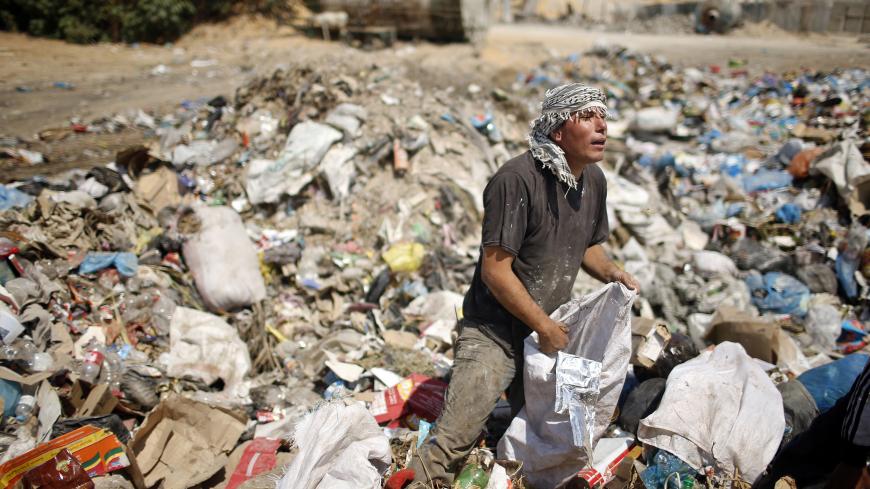 A Palestinian sifts through garbage for salvageable items at a local dump site, in the east of Gaza City September 2, 2013.  REUTERS/Mohammed Salem (GAZA - Tags: ENVIRONMENT SOCIETY) - GM1E9921JCZ01