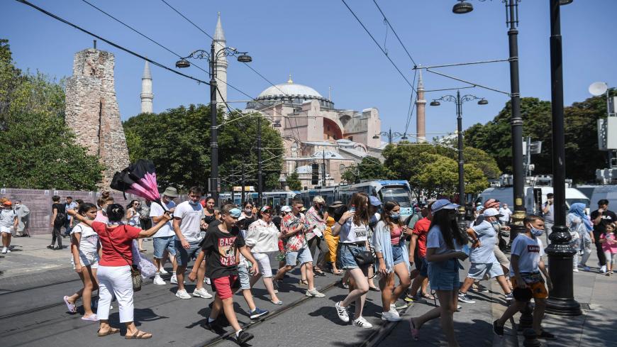 A group of tourists walk past Hagia Sophia as they go toward the historical Sultanahmet district on July 28, 2020 in Istanbul. - The Council of State, the highest administrative court, on July 10, 2020 unanimously cancelled a 1934 decision by modern Turkey's founder Mustafa Kemal Ataturk to turn it into a museum, saying it was registered as a mosque in its property deeds. (Photo by Ozan KOSE / AFP) (Photo by OZAN KOSE/AFP via Getty Images)