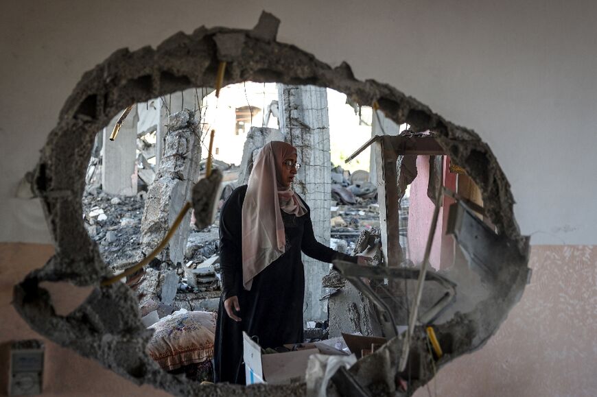 A Palestinian woman checks the rubble of a home hit by Israeli bombing in the southernmost Gaza city of Rafah