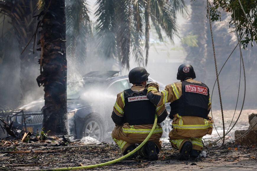 Emergency personnel at a site hit by rockets in the northern Israeli city of Kiryat Shmona