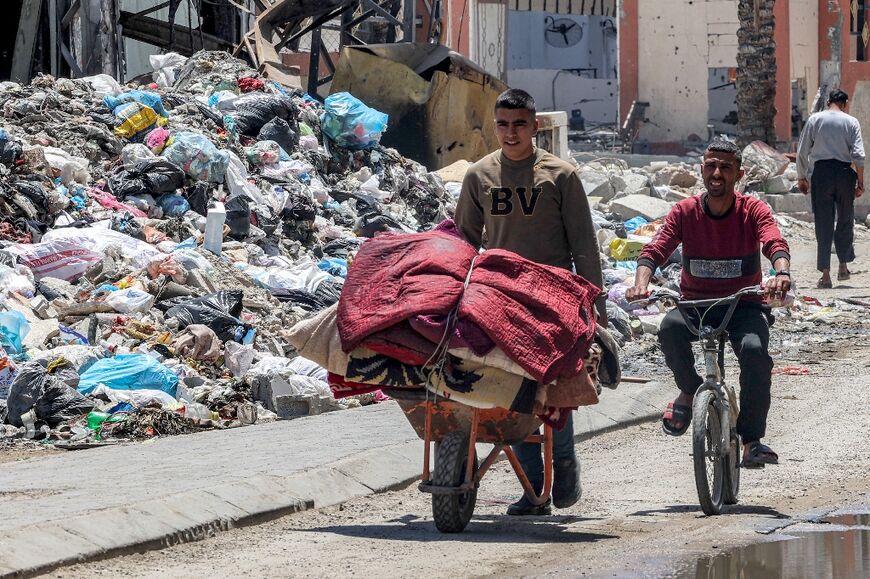 A man uses a wheelbarrow to move belongings in the Gaza City neighbourhood of Zeitun