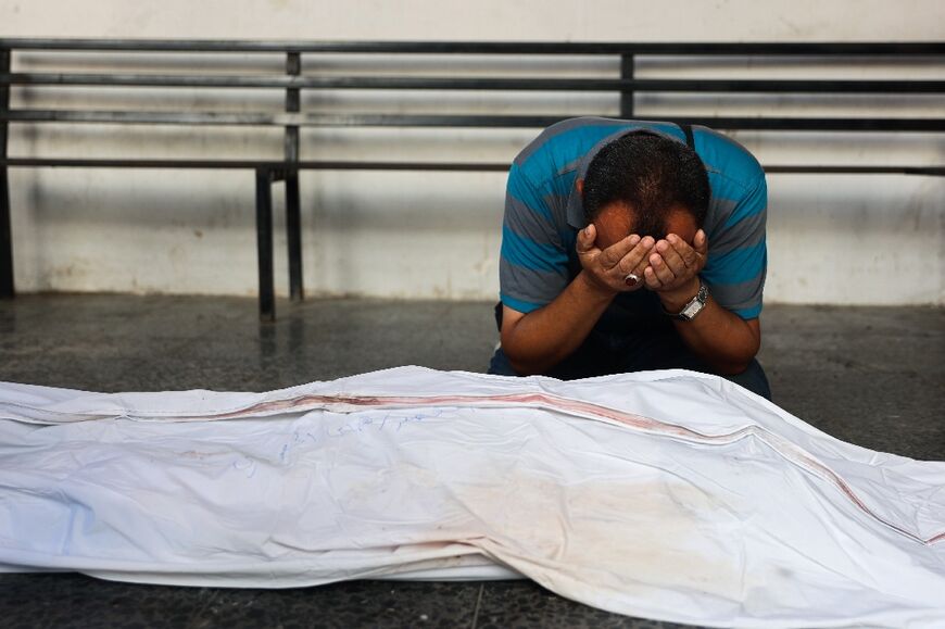 A man mourns by the body of Palestinian doctor Hani al-Jaafarawi, Gaza's ambulance and emergency teams chief, who Palestinian officials say was killed when Israeli warplanes bombed a clinic