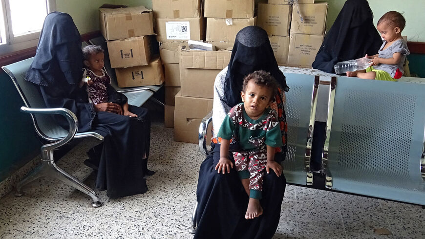 Yemeni women wait with their malnourished children ahead of treatment sessions at a medical center in Yemen's war-ravaged western province of Hodeida, on April 24, 2021. 