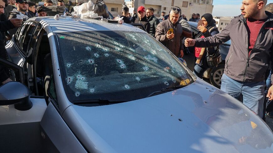 People inspect a bullet-riddled car belonging to three Palestinians killed by Israeli forces in the occupied West Bank city of Nablus