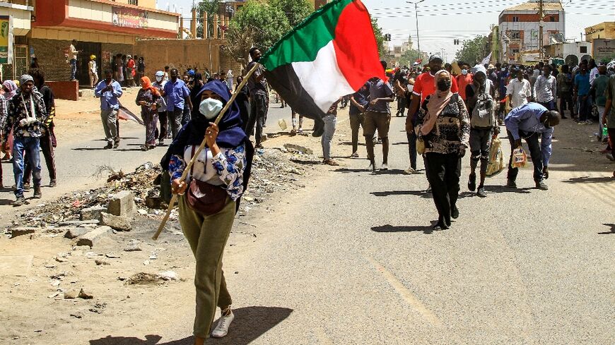 A Sudanese protester waves the national flag on Thursday during the latest rally against a military coup and economic decline