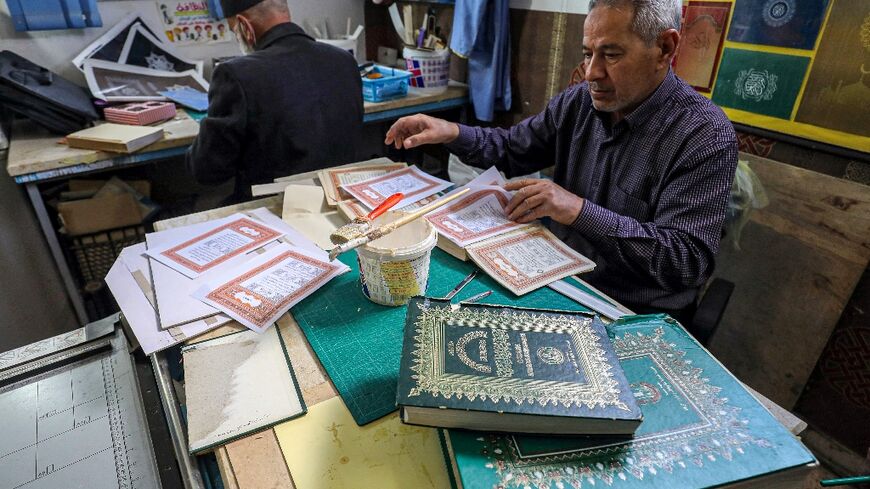A man assembles pages together to be glued into a volume at a workshop for restoring copies of the Holy Koran, Islam's holy book -- an increasingly popular practice as the price of new Korans goes up in Libya