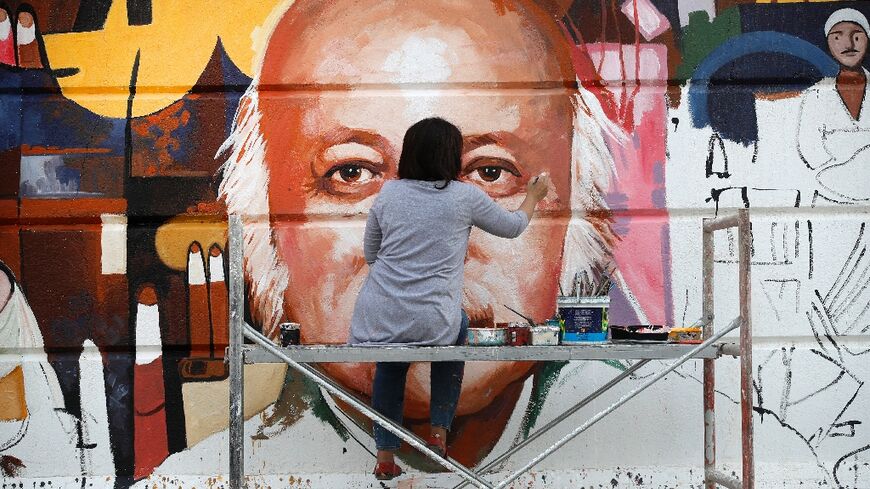 Perched on a scaffold at a busy intersection, 49-year-old Wijdan al-Majed adds final touches to a Baghdad mural dedicated to celebrated Iraqi poet Muzzafar al-Nawab