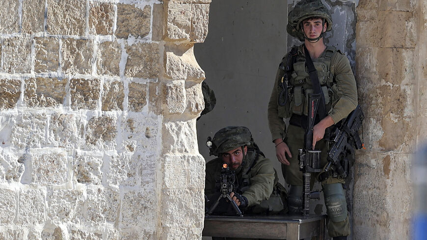 An Israeli soldier takes aim during a raid in the town of Rummanah.