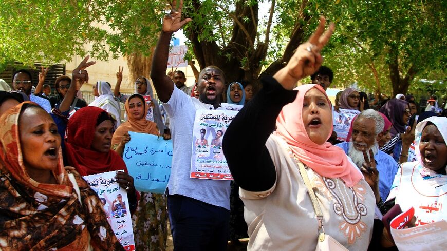 Protesters outside a court in Sudan's capital Khartoum Sunday, where the trial of four accused of fatally stabbing a police general earlier this year opened and was adjourned