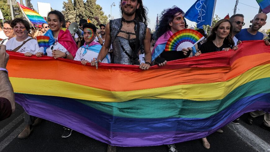 Participants march with a giant rainbow banner during the annual Jerusalem Pride Parade