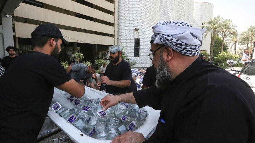 Supporters of Iraqi cleric Moqtada Sadr distribute water to fellow demonstrators, outside Iraq's parliament building on the second day of their occupation 