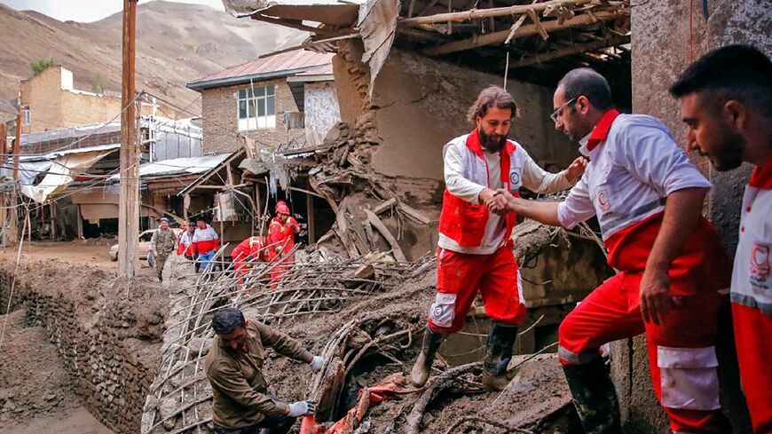 A handout picture from the Iranian Red Crescent shows a rescue team at the site of flash flooding in Emamzadeh Davoud on July 29, 2022