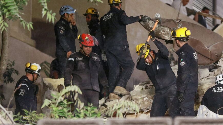 Rescue workers search for people buried under the rubble of a collapsed building in Amman, Jordan