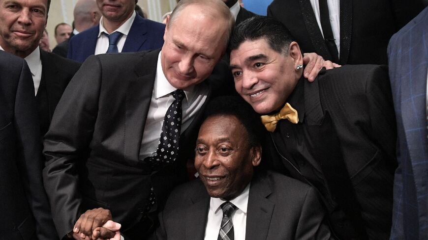 Borrowed aura: Vladimir Putin joins Pele and Diego Maradona as they pose ahead of the World Cup draw in Moscow in 2017 