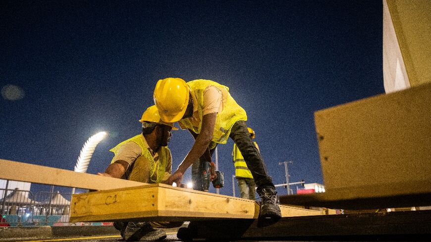 Labourers work to build a structure along a street in Doha on November 2, 2022, ahead of the Qatar World Cup football tournament