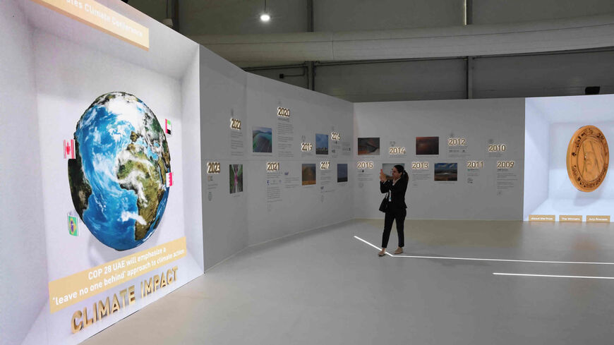 A woman takes a photo of a display at the Sharm el-Sheikh International Convention Center during the COP27 climate conference, Sharm el-Sheikh, Egypt, Nov. 15, 2022.